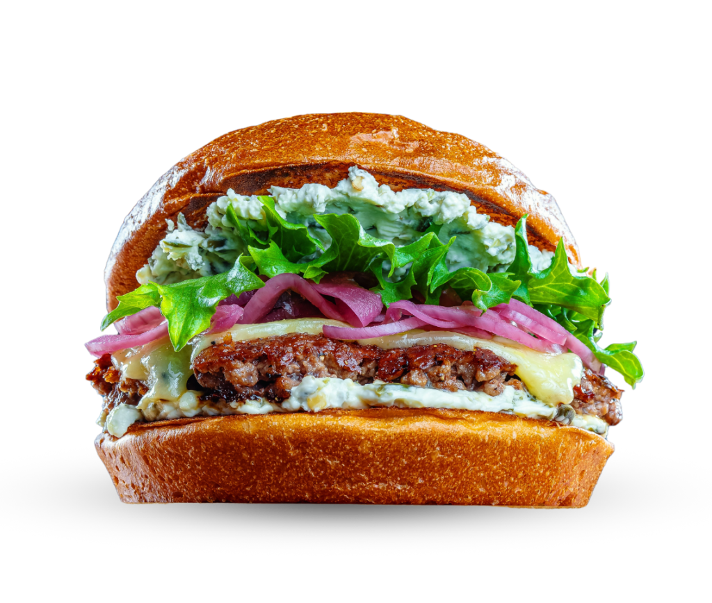 burgeri jossa salaattia, punasipulia ja valkoista kastiketta
